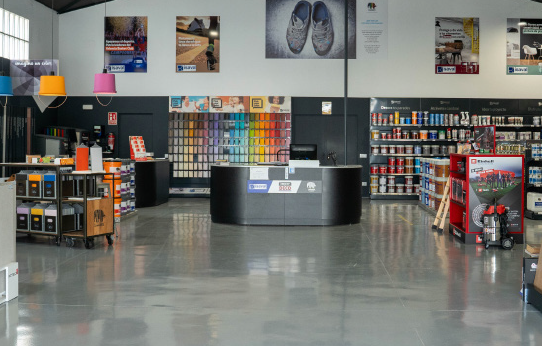 Mostrador de atención al cliente en una tienda de pinturas con una variedad de colores y productos de decoración.