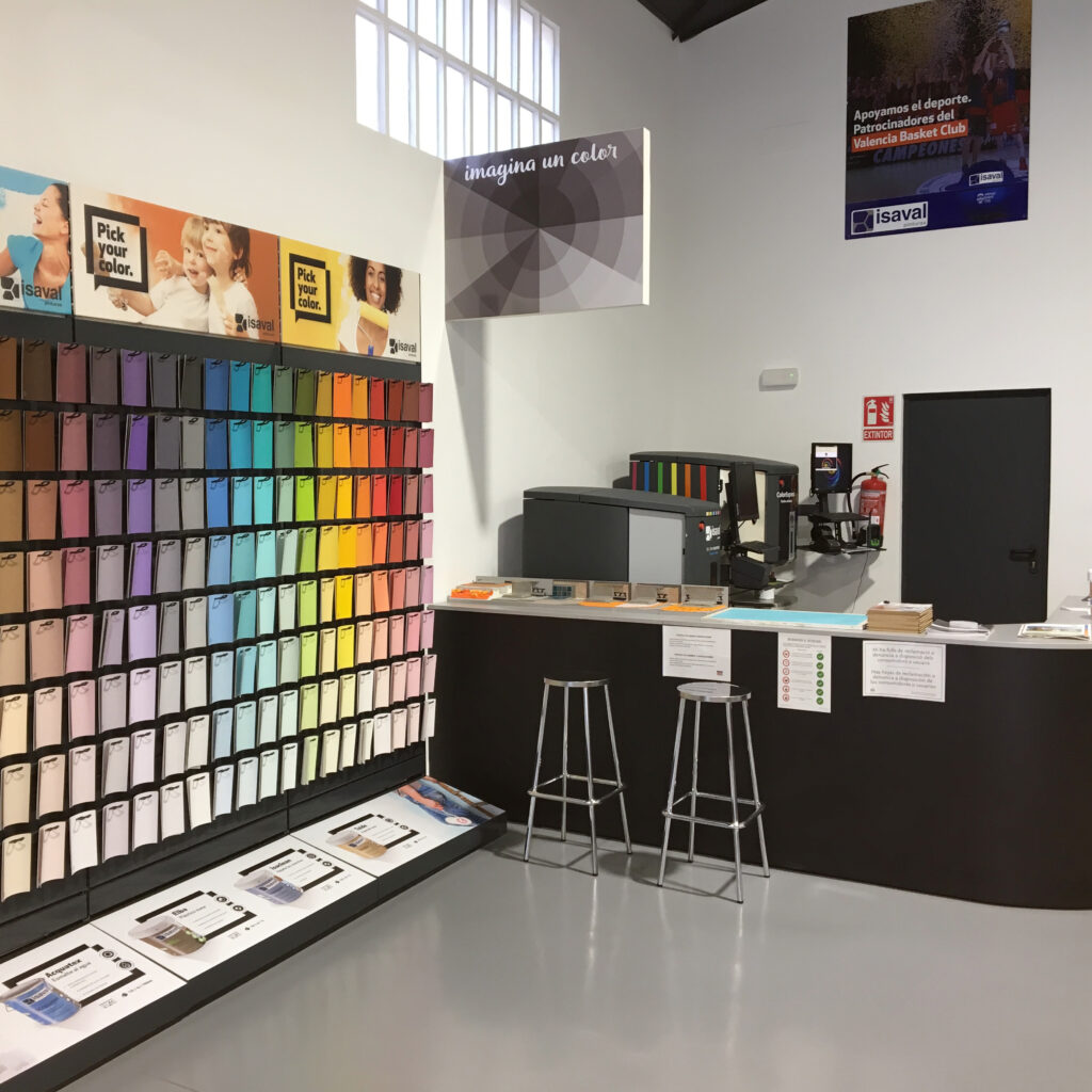 Muestra de colores de pintura en un espacio de exhibición con un área de servicio al cliente.